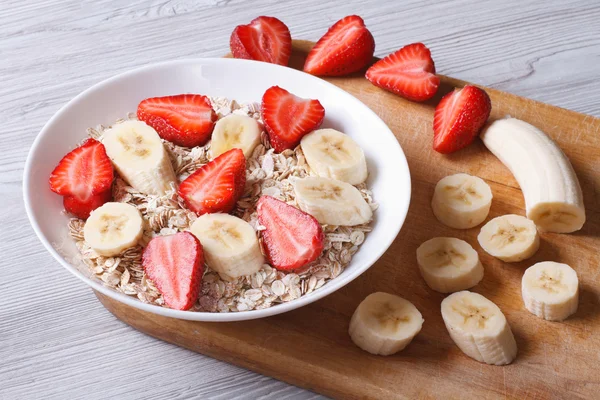 Müsli mit Erdbeeren und Banane mit horizontalen Zutaten — Stockfoto