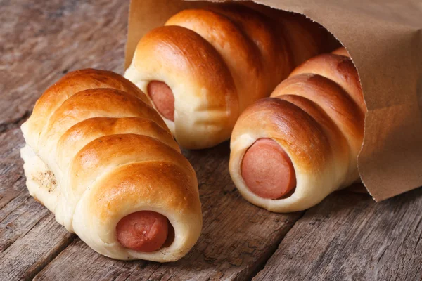 Three roll with sausage close up in a paper bag — Stock Photo, Image