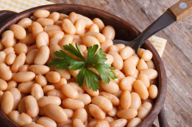 ahşap makro üst üzerinde kahverengi bir kasede beyaz fasulye göster