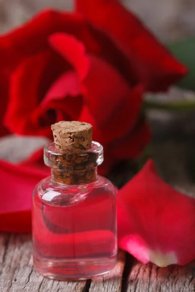 Ароматное розовое масло в бутылке по вертикали деревянного стола — стоковое фото