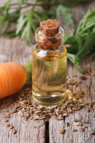 Medikovaných olej mrkev semen ve skleněné láhvi na stůl — Stock fotografie
