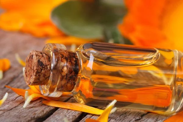 Calendula extract and flowers on an old table macro — Stock Photo, Image