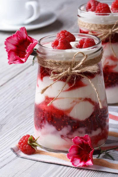 Raspberry yogurt closeup on a table decorated with flowers — Stock Photo, Image