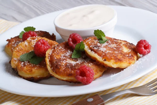 Cheese pancakes with raspberries and sour cream horizontal — Stock Photo, Image