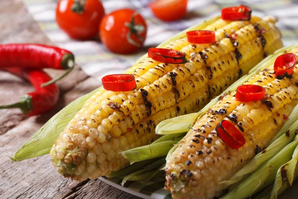 Hot grilled corn with chili peppers on old wooden table — Stock Photo, Image