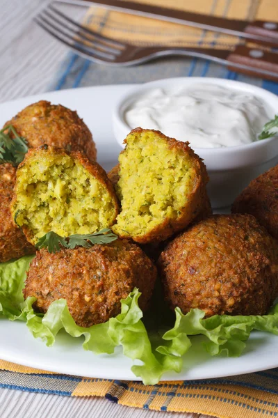 Falafel pe frunze de salată verde cu sos tzatziki, vertical — Fotografie, imagine de stoc