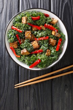 Kızarmış tofu, biber, lahana ve susam tohumlarından yapılmış diyet salatası. Masanın üzerinde yakın plan. Yukarıdan dikey üst görünüm