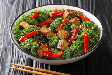 Masadaki kasede teriyaki tofu salatası, dolma biber, lahana ve susam tohumları servis ediliyor. yatay