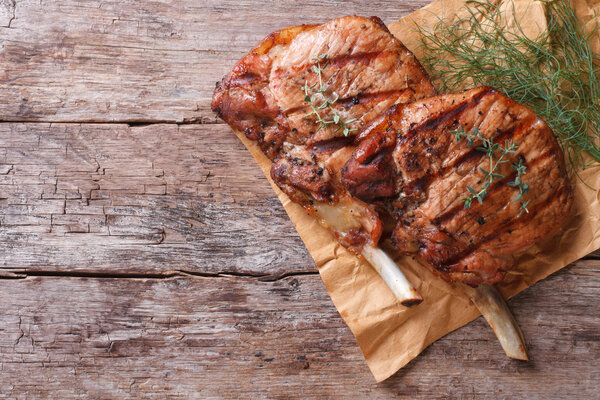 grilled pork with herbs on an old table top view close-up 