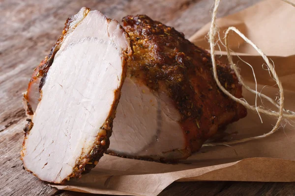 Baked pork tenderloin closeup on paper, horizontal — Stock Photo, Image