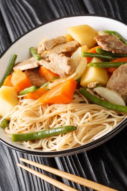 Nikujaga tarifi domuz eti ve patates güveci Savory Soya Sosu Köklü Dashi çorbası ahşap masadaki kaseye yakın. Dikey