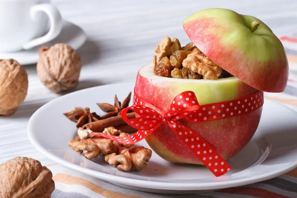 Red apple with nuts and raisins and coffee on the table — Stock Photo, Image