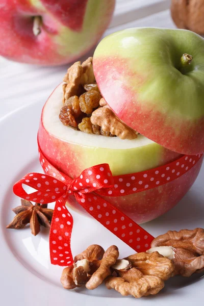 Праздничное красное яблоко с орехами и изюмом вертикально — стоковое фото