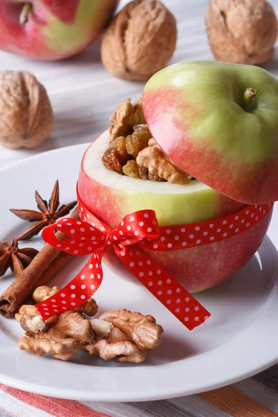 Свежее красное яблоко с орехами и изюмом вертикально — стоковое фото