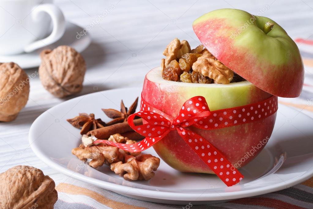 Red apple with nuts and raisins and coffee on the table