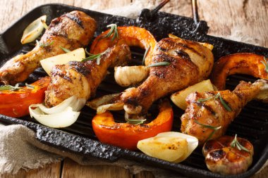 Sağlıklı barbekü yemekleri ızgara tavuk budu ve sezonluk sebzeler masanın üstünde ızgara tepside yakın plan. yatay