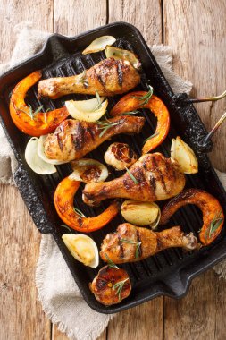 Izgara tavuk bacağı, balkabağı, soğan ve yakın plan sarımsak masada. Yukarıdan dikey üst görünüm