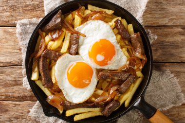 Chorrillana, dilimlenmiş et, sahanda yumurta ve soğan ile kaplanmış patates kızartmalarından oluşan bir yemektir. Yukarıdan yatay üst görünüm