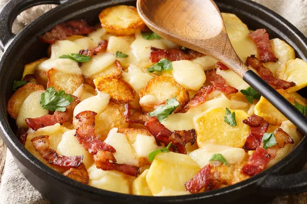 Truffade Potato Cake with Cheese and Bacon Recipe close up in the pan on the table. Horizonta