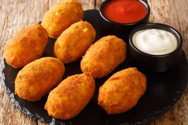 Sos soslu Croquetas de Bacalao Cod Croquette masadaki tabağa yakın. Yatay