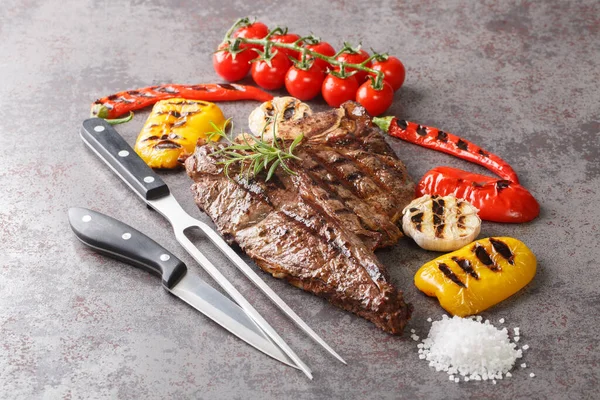 Lezzetli biftek lokantası bifteği ve gri arka planda rengarenk taze sebzeler. Yatay