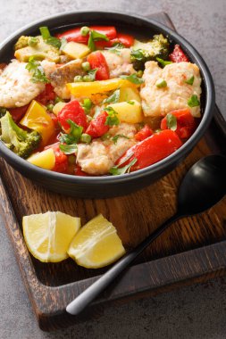 Mevsimlik sebzelerle dolu balık güveci masanın üzerindeki bir kasede. Dikey. Akdeniz stili