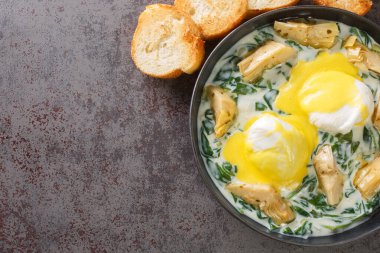 New Orleans usulü yumurta sardou haşlanmış enginarlı yumurta, ıspanak ve Hollandaise masadaki tabağa yakın. Yukarıdan yatay üst görünüm