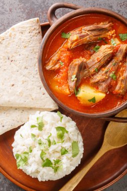 Hilachas, domates sosu ve domates, patates, havuç ve Guajillo biberleriyle servis edilen doğranmış bir Guatemala yemeğinden oluşur. Yukarıdan dikey üst görünüm