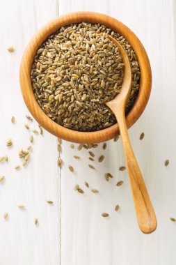 Çiğ freekeh ya da firik, kavrulmuş buğday kabı beyaz ahşap masada. Yukarıdan dikey üst görünüm