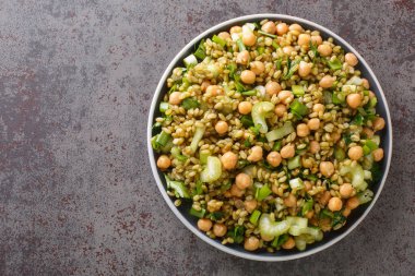 Masadaki tabakta nohut, kereviz ve otlarla serbest diyet salatasının yakın çekimi. Yukarıdan yatay üst görünüm