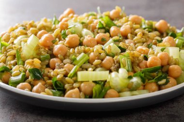 Masada taze vejetaryen salatası, nohut, kereviz ve otlar var. yatay