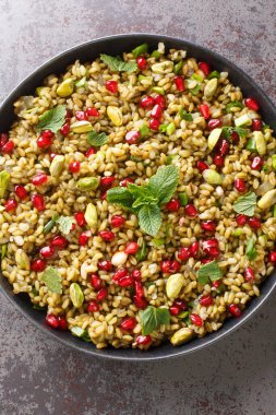 Sebzeli salata, nar, fındık ve otları masaya yakın bir tabakta. Yukarıdan dikey üst görünüm