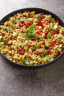 Sebzeli salata, nar, fındık ve otları masaya yakın bir tabakta. Dikey