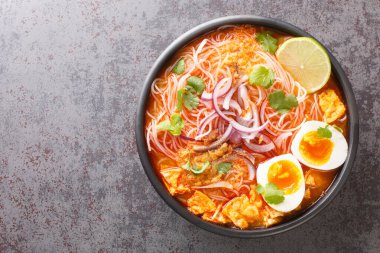 Birmanya Mohinga Pirinç Erişteli Balık Çorbası masanın üzerindeki kaseye yakın plan. Yukarıdan yatay üst görünüm