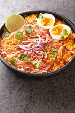 Mohinga, kedibalıklı, pilav erişteli, tavuk yumurtalı ve limonlu balık çorbası. Dikey