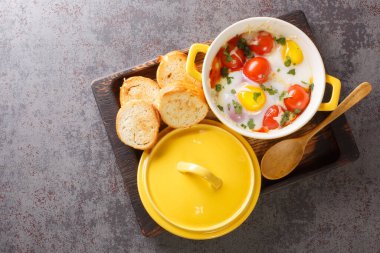 Krem peynirli yumurta ve sıcak tostla servis edilen Cocotte yumurtaları masadaki ahşap tepsiye yakın çekim için. Yukarıdan yatay üst görünüm