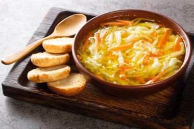 Vejetaryen sebze jülyen çorbası, ahşap bir tepside yakın plan tost ile servis edilir. Yatay