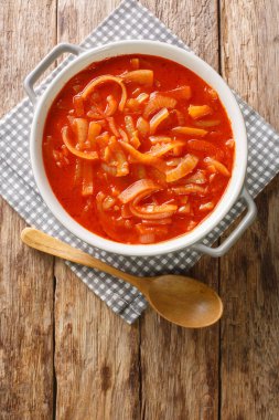 Cebolada, ahşap bir masanın üstündeki tencerede yakın çekim için soğanla yapılan geleneksel bir Portekiz sosudur. Yukarıdan dikey üst görünüm