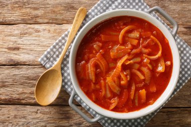 Cebolada, ahşap bir masanın üstündeki tencerede soğanla dolu bir Portekiz sosudur. Yukarıdan yatay üst görünüm