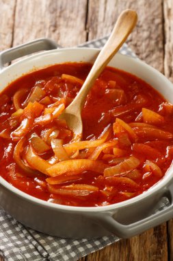 Cebolada, ahşap bir masanın üstündeki tencerede yakın çekim için soğanla yapılan geleneksel bir Portekiz sosudur. Dikey