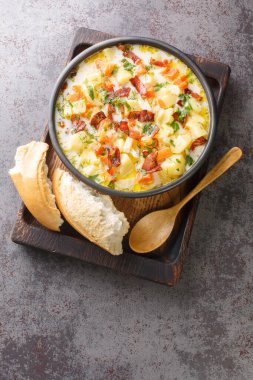 Geleneksel domuz pastırmalı Polonya Patates Çorbası. Tahta tepsinin üzerindeki kaseye yakın plan. Yukarıdan dikey üst görünüm
