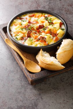 Geleneksel domuz pastırmalı Polonya Patates Çorbası. Tahta tepsinin üzerindeki kaseye yakın plan. Dikey