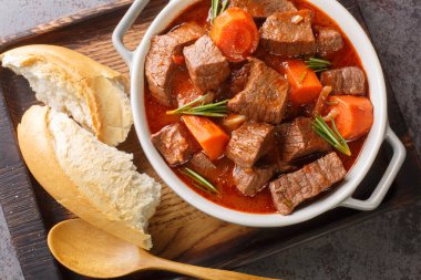Masadaki tahta tepside Daube de Boeuf Provencal olarak bilinen kırmızı şarapta Fransız sığır eti güveci. Yukarıdan yatay üst görünüm