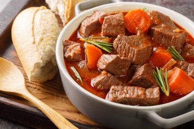 Masadaki tahta tepside Daube de Boeuf Provencal olarak bilinen kırmızı şarapta Fransız sığır eti güveci. Yatay