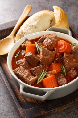 Daube Provencal Fransız usulü ağır ateşte pişirilmiş kırmızı şarap ve masadaki ahşap tepside yakın plan sebze güveci. Dikey