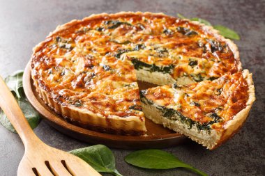 Ispanaklı, peynirli, yumurtalı ve baharatlı Quiche Florentine spatula ile yakın plan. Hotizonta