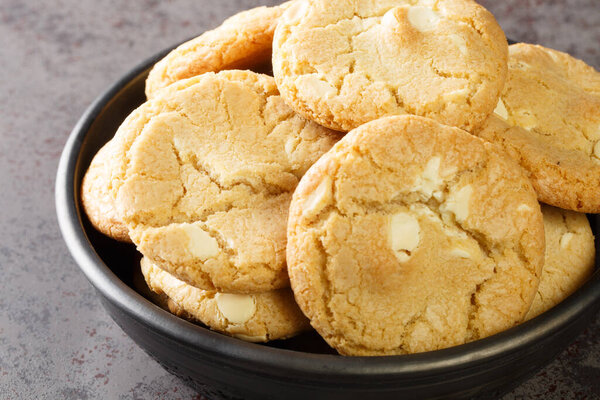 White chocolate biscuit cookies and macadamia nuts in the plate on the table close-up. Horizonta
