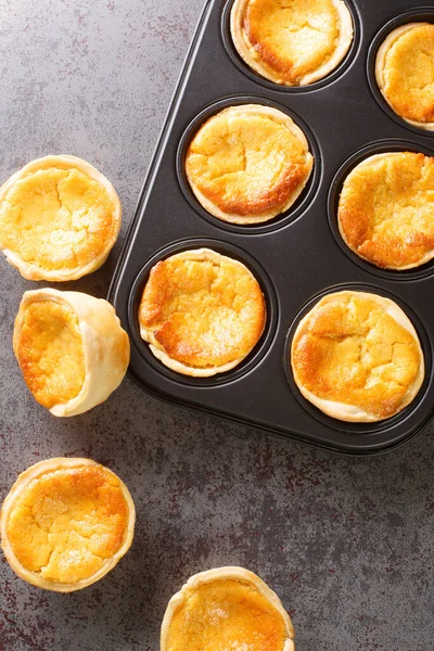 Tarts Queijadas ve kremalı yakın plan bir fırın tabağı. yukarıdan dikey üst görünüm