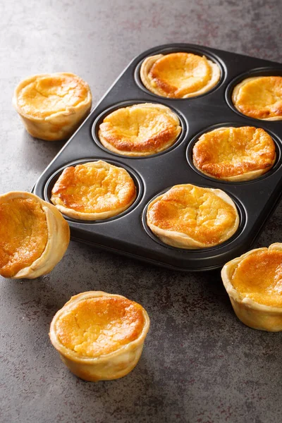Tarts Queijadas ve kremalı yakın plan bir fırın tabağı. dikey