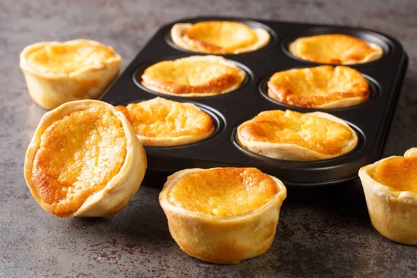 Queijada 's Portuguese Custard Cupcakes' i masadaki fırın tabağında yakın plan çekimde. Yatay